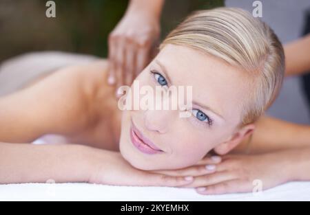 Ich liebe jede Sekunde ihrer Behandlung. Eine junge Frau, die eine entspannende Massage genießt. Stockfoto