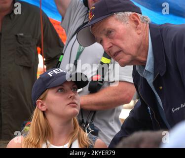 Hurrikan Katrina, Hancock County, Mississippi, 8. September 2005 – der ehemalige Präsident George H. W. Bush spricht mit dem Vertreter der FEMA Meredith Chandler während seines Besuchs im Waveland Disaster Recovery Center (DRK). Präsident Bush bereist die Küsten des Mississippi und Louisiana Golf, um die durch den Hurrikan Katrina verursachten Schäden und die laufenden Wiederaufbaubemühungen zu sehen. Stockfoto