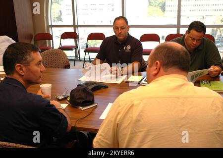 Hurrikan Katrina, Jackson, Mississippi, 12. Oktober 2005 – Konteradmiral John Acton, USCG (links, rückwärtsgerichtet) Besuche mit Deputy Federal Coordinating Officer (DFCO) Nick Russo (Zentrum) im Joint Field Office in Jackson, Mississippi. Die FEMA und die Küstenwache arbeiten zusammen an den Wiederaufbaumaßnahmen für den Hurrikan Katrina. Stockfoto
