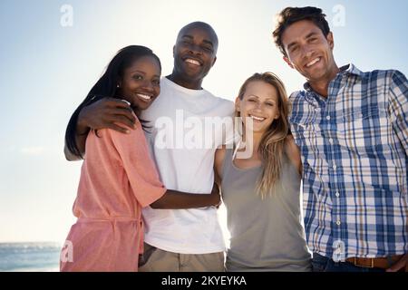 Es ist toll, Zeit mit engen Freunden zu verbringen. Verkürztes Porträt von zwei glücklichen Paaren, die einen Tag am Strand genießen. Stockfoto