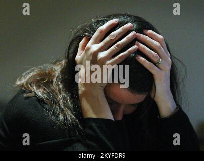 BILD, DAS VON EINEM MODELL DARGESTELLT WIRD. Aktenfoto von 08/11/07 einer Frau, die ihren Kopf in den Händen hält. Die Zahl der jungen Menschen, die in psychiatrische Erwachsenenstationen aufgenommen wurden, ist seit dem letzten Jahr gestiegen, wie ein neuer Bericht zeigt. In den Jahren 2021 und 22 wurden 80 junge Menschen in vorwiegend Erwachsenenstationen für psychische Behandlung aufgenommen, gegenüber 62 in den Jahren 2020 und 21. Ausgabedatum: Donnerstag, 1. Dezember 2022. Stockfoto