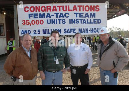 Hurricane Katrina, Harrison County, Mississippi, 14. Februar 2006 – Bob Weber, FEMA (von links nach rechts), Steven Overton, Bechtel, FEMA Deputy Federal Coordinating Officer (DFCO) Jesse Munoz und Troy Whiddon, Bechtel feiern die Installation von 35.000 Reiseanhängern in Mississippi. Die FEMA stellt Reiseanhänger als eine Form der vorübergehenden Unterbringung für die vom Hurrikan Katrina betroffenen Einwohner zur Verfügung. Mark Wolfe/FEMA Stockfoto