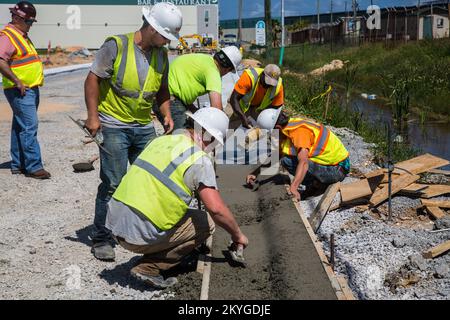 Biloxi, MS, 6. Mai 2015 - Bauarbeiter von Oscar Renda Contracting beendet Betonarbeiten für den Austausch von Bordsteinen und Rinnen nach der Installation neuer Wasser- und Abwasserleitungen unter der 8.. Straße in Biloxi, MS. Die Wiederherstellung der Wasser- und Kanalisationsinfrastruktur von Biloxi ist Mississippis größtes FEMA-Projekt zur öffentlichen Unterstützung im Zusammenhang mit dem Wiederaufschwung durch den Hurrikan Katrina. Stockfoto