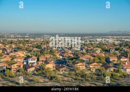 Phoenix, Arizona - Blick auf die Unterteilung von oben auf dem Pima Canyon Wanderweg. Vor dem eingezäunten Wohnhaus sind saguaro-Kakteen Stockfoto