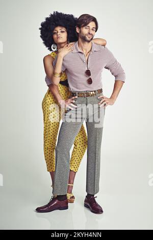 Retro-Paar. Ein attraktives junges Paar, das in Retro-70s-Kleidung zusammensteht. Stockfoto