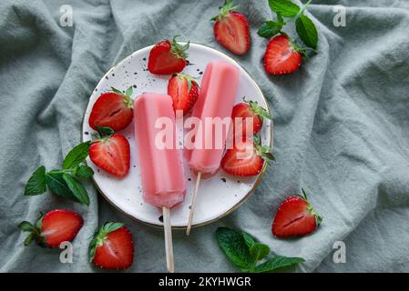 Hausgemachte gefrorene Erdbeer-Eiscreme, Eiszapfen und frische Erdbeeren. Sommerdessert Stockfoto