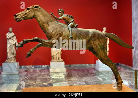 Der Jockey der Artemision große hellenistische Bronzestatue, ein Junge, der auf einem Pferd reitet, datiert auf etwa 150–140 v. Chr., Bronzestatue aus dem antiken Griechenland, griechische Skulptur eines Rennpferdes, vor der Zerstörung gerettet, als es in der Antike bei einem Schiffbruch verloren ging, entdeckt im zwanzigsten Jahrhundert, den Göttern gewidmet. Nationales Archäologisches Museum in Athen. Stockfoto