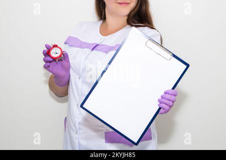 Eine Frau zeigt mit dem Finger auf eine Tafel für Papier in ihren Händen Stockfoto