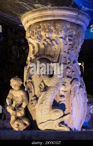 Der Sockel (Schacht) unter dem Becken des Neptun-Brunnens in Danzig, Polen. Verzierung mit stilvollen Blattmotiven mit Skulpturen eines Delfins, Stockfoto