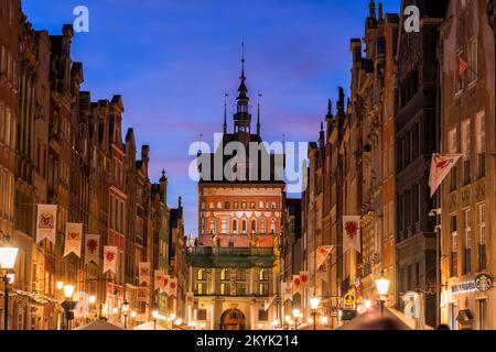 Abend in der Altstadt von Danzig in Polen. Historische Bürgerhäuser entlang der Long Street (Ulica Długa) mit Blick auf den Gefängnisturm und das Goldene Tor Stockfoto