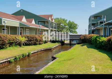 Destin, Florida - Creek mit Graslandküste in der Mitte eines Business plaza in der Nähe des Strandes. Es gibt eine Holzbrücke über dem Bach, die den r verbindet Stockfoto