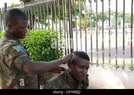 Soldat, der sich die Haare schneiden lässt, Kinshasa, Demokratische Republik Kongo - mit Rasiermesser und Kamm Stockfoto