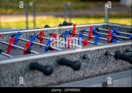 Fußballtisch im Freien, um mit roten und blauen Spielern Fußball zu spielen, Nahaufnahme Stockfoto