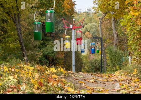 Farbenfrohe Kabinen im Erholungspark der Stadt Kharkiv mit Wanderweg und herbstfarbenen Blättern Stockfoto