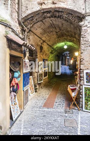 Dolceacqua, Italien - 06-07-2021: Charakteristische kleine Straßen im historischen Zentrum von Dolceacqua mit Bögen und Blumen Stockfoto