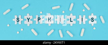 Medizin und Gesundheit. Auf blauem Hintergrund gibt es Pillen und Rätsel mit der Inschrift - SYPHILIS Stockfoto