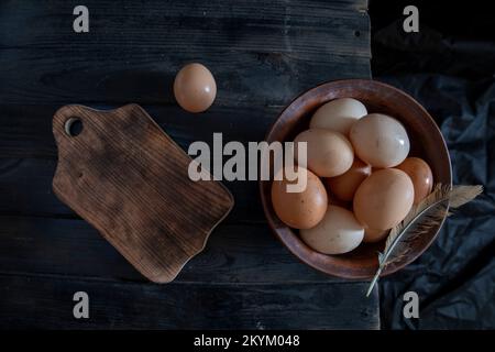 Frische Eier von Bio-Bauernhöfen in einer Holzschüssel auf einem Holztisch Stockfoto