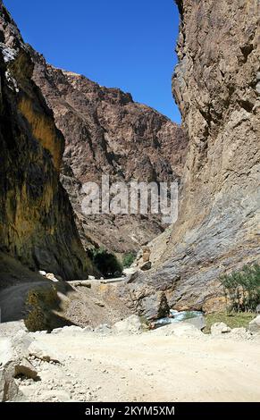 Die Straße führt durch eine enge, felsige Schlucht auf der südlichen Route zwischen Kabul und Bamyan (Bamiyan) in Afghanistan. Stockfoto