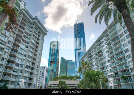 Luxusresidenzen in Miami, Florida, unter den hellen Wolken am Himmel. Es gibt zwei mittelhohe Wohnungen auf beiden Seiten an der Vorderseite und Hochhäuser Stockfoto