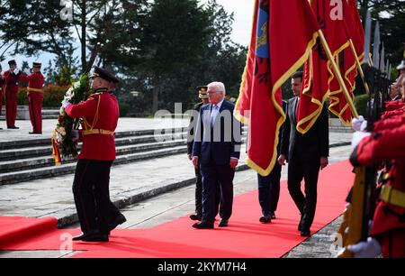 Tirana, Albanien. 01.. Dezember 2022. Der deutsche Präsident Frank-Walter Steinmeier (Zentrum) legt zusammen mit der Bürgermeisterin von Tirana, Erion Veliaj (verdeckt), einen Kranz auf dem Heldenfriedhof am Denkmal Mutter Albanien. Präsident Steinmeier besucht die Länder Nordmazedoniens und Albaniens während seiner viertägigen Reise auf den Balkan. Neben der Lage in der Region und den Auswirkungen des russischen Angriffskriegs in der Ukraine wird sich die Reise auf die Unterstützung Deutschlands für die Aussichten der Länder auf einen Beitritt zur Europäischen Union konzentrieren. Kredit: Bernd von Jutrczenka/dpa/Alamy Live News Stockfoto