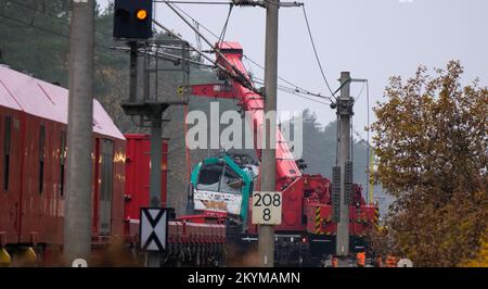 Leiferde, Deutschland. 01.. Dezember 2022. Eine unfallgeschädigte Lokomotive wird mit einem Kran auf einen Wagen gehoben. Die Sanierungsarbeiten werden nach einem Zugunglück auf der Eisenbahnstrecke zwischen Hannover und Berlin fortgesetzt. Am 17. November hatte ein Zug aus 25 mit Propangas gefüllten Panzern mit einem anderen Zug zusammengestoßen, der an einem Signal nahe Leiferde im Bezirk Gifhorn angehalten hatte. Kredit: Philipp Schulze/dpa/Alamy Live News Stockfoto