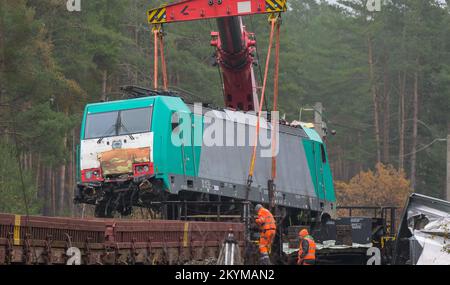 Leiferde, Deutschland. 01.. Dezember 2022. Eine unfallgeschädigte Lokomotive wird mit einem Kran auf einen Wagen gehoben. Die Sanierungsarbeiten werden nach einem Zugunglück auf der Eisenbahnstrecke zwischen Hannover und Berlin fortgesetzt. Am 17. November hatte ein Zug aus 25 mit Propangas gefüllten Panzern mit einem anderen Zug zusammengestoßen, der an einem Signal nahe Leiferde im Bezirk Gifhorn angehalten hatte. Kredit: Philipp Schulze/dpa/Alamy Live News Stockfoto