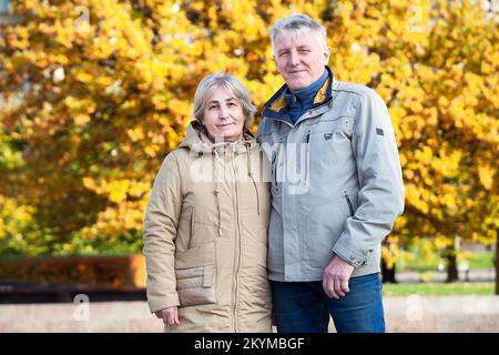 Pensionsalter Paar Porträt zusammen im Herbst Stadtpark, glückliche Ältere Porträt Stockfoto