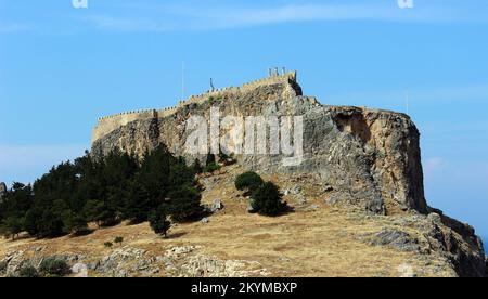 Rhodos, Griechenland 7. Mai 2012: Alte Stadtfestung auf einer Klippe und moderne Häuser in der Nähe Stockfoto