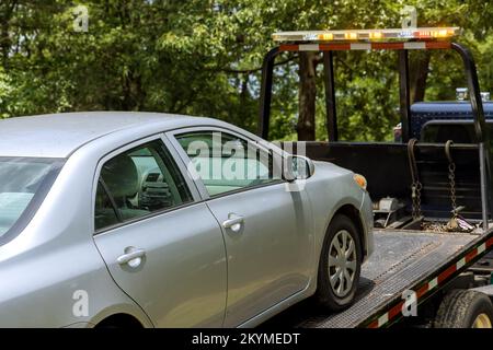 Arbeiten im Abschleppdienst, Verladen eines beschädigten Fahrzeugs, das auf einen Abschleppwagen geworfen wurde Stockfoto