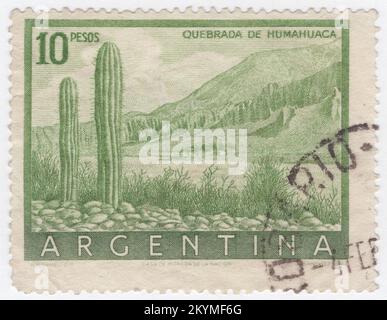 ARGENTINIEN - 1955: Gelb-grüne Briefmarke mit 10 Pesos, die die Klippen von Humahuaca darstellt. Das Quebrada de Humahuaca ist ein schmales Gebirgstal in der Provinz Jujuy im Nordwesten Argentiniens. Es ist etwa 155 km lang, Nord-Süd ausgerichtet, im Westen und Norden vom Altiplano begrenzt, im Osten von den Hügeln der Sub-Anden und im Süden von den warmen Tälern. Der Name quebrada (wörtlich „gebrochen“) übersetzt sich als tiefes Tal oder Schlucht. Sie erhält ihren Namen von Humahuaca, einer kleinen Stadt mit 11.000 Einwohnern Stockfoto