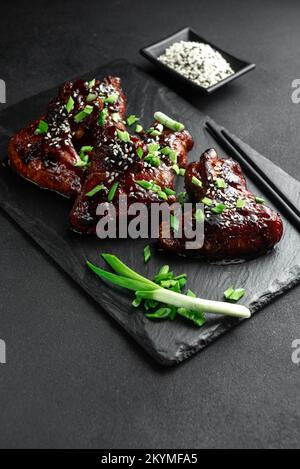 Hähnchenflügel in süßer und saurer Sauce. Hähnchenflügel in Cola. Asiatisches Essen Stockfoto