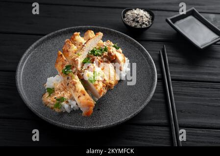 Asiatisches Gericht mit Reis und Huhn. Nasi Hainan oder Hainan-Huhn. Hainan Chicken Rice ist ein Gericht aus pochiertem Hähnchen und gewürztem Reis. Draufsicht Stockfoto