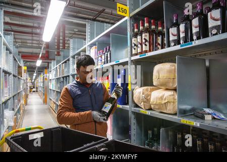 Das Bild vom 2022. November zeigt das einzige Versandzentrum von Amazon in Großbritannien, das Alkohol in Rugby, Warwickshire, behandelt. Das Personal arbeitet im Klo Stockfoto