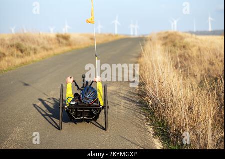 Sportler mit Behinderungstraining mit seinem Handbike auf der Rennstrecke. Hochwertige Fotografie. Stockfoto