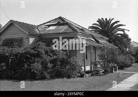 Ein heruntergekommener alter Holzbungalow an der Kreuzung von Merewether und Lingard Street, Merewether, Newcastle, New South Wales, Australien, 1993. Schwarz-weiß-Behandlung. Stockfoto