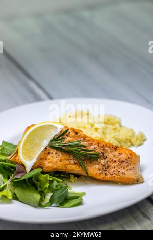 Gegrillter Lachs serviert mit Couscous und Gemüsesalat Stockfoto