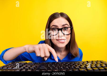 Foto eines jungen gestressten nervösen, attraktiven, süßen, verrückten Geschäftsfrauen, Programmierer und Fingerspitze, isoliert auf gelbem Hintergrund Stockfoto