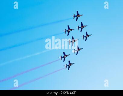 Fluggeschwader fliegen mit Farbspuren in blauem, rotem Weiß Stockfoto