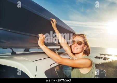 Entladen Sie den Gepäckträger auf dem Dach des Fahrzeugs, wenn Sie auf dem Urlaubsparkplatz stehen Stockfoto