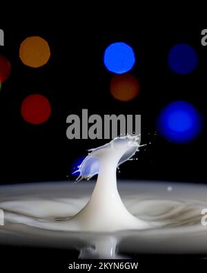 Ein milchiger Tropfen Wasser mit einem farbigen Hintergrund Stockfoto