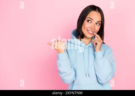 Foto der niedlichen Tricky Lady trägt blauen Hoodie Finger Lippen zeigen Daumen leer isolierter rosafarbener Hintergrund Stockfoto