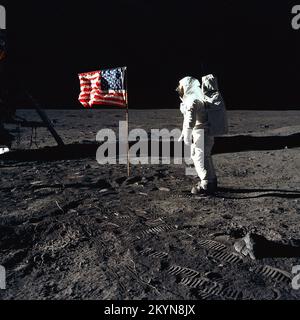 Astronaut Buzz Aldrin, Pilot der Mondlandefähre der ersten Mondlandung Mission, posiert für ein Foto neben der bereitgestellten USA Flagge während der Apollo 11 Extravehicular Activity (EVA) auf der Mondoberfläche. Die Mondlandefähre (LM) ist auf der linken Seite, und die Fußspuren der Astronauten sind deutlich sichtbar im Boden des Mondes. Astronaut Neil A. Armstrong, Kommandant, nahm dieses Bild mit einem 70 mm Hasselblad lunar Surface-Kamera. Während Astronauten Armstrong und Aldrin in der LM abstammen, Befehl "Adler", zur Erkundung der Region Meer der Ruhe, des Mondes, Astronaut Michael Collins, modu Stockfoto