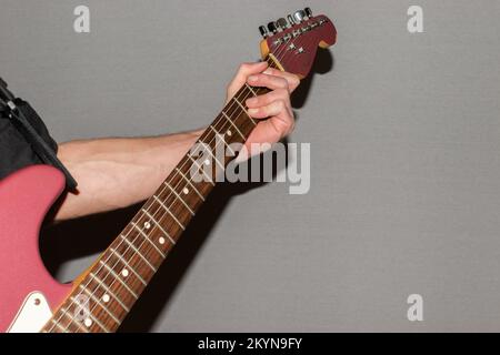 Vaduz, Liechtenstein, 11. Januar 2022 Musiker spielt einen Fender Stratocaster USA Crafted 1995 in der Farbe Burgunder Nebel Stockfoto