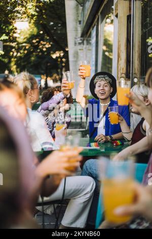 Ein glücklicher junger Mann, der mit Freunden einen Drink genießt Stockfoto