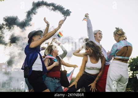 Fröhliche multirassische Freunde tanzen während der Schwulenparade Stockfoto