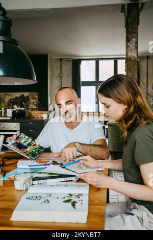 Geschäftskollegen diskutieren über Fotos, während sie im Studio arbeiten Stockfoto