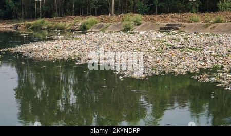 Tag der Verschmutzungskontrolle, durch Plastik und Müll verschmutzter Fluss, auf Flusswasser schwimmende Abfallmaterialien, Verschmutzungskontrolle Stockfoto