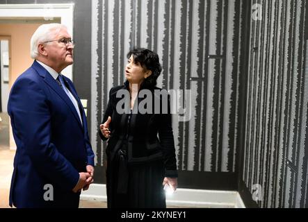 01. Dezember 2022, Albanien, Tirana: Bundespräsident Frank-Walter Steinmeier besucht das Museum "Haus der Blätter" und wird durch die Ausstellung geführt von der Regisseurin Etleva Demollari. In diesem Raum des Museums stehen Tausende von Namen von Opfern des Hoxha-Regimes an den Wänden. Während seiner viertägigen Reise auf den Balkan besucht Präsident Steinmeier die Länder Nordmazedoniens und Albaniens. Neben der Lage in der Region und den Auswirkungen des russischen Angriffskriegs in der Ukraine wird sich die Reise auf die Unterstützung Deutschlands für die Aussichten der Länder auf einen Beitritt konzentrieren Stockfoto