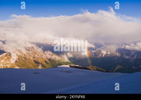 Regenbogen im Bergtal nach dem Regen. Stockfoto