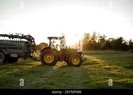 Traktor auf dem Feld bei Sonnenuntergang Stockfoto